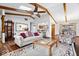 Bright living space featuring vaulted ceilings, wood beams, a brick fireplace, and a connected kitchen area at 7326 Caboose Ct, Indianapolis, IN 46256