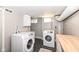 Functional laundry room with modern machines, gray walls, and utility cabinets at 764 E 42Nd St, Indianapolis, IN 46205