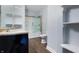 Bathroom featuring updated fixtures, open shelving, and a shower with glass doors at 832 N Parker Ave, Indianapolis, IN 46201