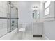 Bright bathroom featuring marble-look tile, new vanity, shower and tub combo, and large window at 832 N Parker Ave, Indianapolis, IN 46201