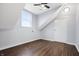 Bedroom featuring hardwood floors, slanted ceilings, and natural light from the window at 832 N Parker Ave, Indianapolis, IN 46201