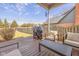 Outdoor seating and a grill are arranged on a covered patio in this spacious backyard at 9046 Pinecreek Ct, Indianapolis, IN 46256