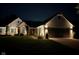 Night view of home with landscape lighting, accentuating the brick facade and architectural details at 9046 Pinecreek Ct, Indianapolis, IN 46256