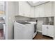 Well-organized laundry room with front-load washer/dryer, ample cabinet storage, and a utility sink at 9046 Pinecreek Ct, Indianapolis, IN 46256