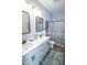 Well-lit bathroom with double sinks, gray cabinets, decorative mirrors, and stylish accents at 9748 Junction Station, Fishers, IN 46037