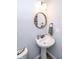 Cozy half bathroom with a pedestal sink, stylish mirror, and modern lighting fixtures at 9748 Junction Station, Fishers, IN 46037