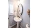 Bright powder room features pedestal sink, shuttered window, and decorative mirror at 9748 Junction Station, Fishers, IN 46037