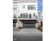 A modern townhome featuring a garage with a metal door and a small second story balcony at 9748 Junction Station, Fishers, IN 46037