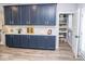 Kitchen cabinets painted dark blue compliment the floors and white marble countertops with a walk-in pantry at 9748 Junction Station, Fishers, IN 46037