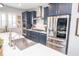 Gourmet kitchen boasts navy cabinetry, stainless steel appliances, a large island, and sleek pendant lighting at 9748 Junction Station, Fishers, IN 46037