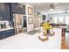 Kitchen island with white countertop and stainless steel refrigerator; open floor plan into a dining and living area at 9748 Junction Station, Fishers, IN 46037