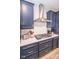 Kitchen with stainless steel hood vent, cooktop, and white subway tile backsplash, plus dark blue cabinets at 9748 Junction Station, Fishers, IN 46037