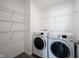Clean laundry room equipped with a modern washer and dryer, and shelving for organized storage at 9858 Oakmont E Dr, Pendleton, IN 46064