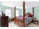 Charming bedroom with four poster bed, a patterned bedspread, and windows with sheer curtains at 9970 Southwind Dr, Indianapolis, IN 46256