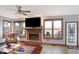 Cozy living room features a brick fireplace, windows overlooking the backyard, and a ceiling fan at 9970 Southwind Dr, Indianapolis, IN 46256