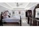 Spacious main bedroom featuring a tray ceiling with fan, light gray walls, and beautiful wood furniture at 9970 Southwind Dr, Indianapolis, IN 46256