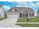 Charming home featuring a two-car garage, nicely manicured lawn, and stylish architectural details at 1051 Macoun Dr, Westfield, IN 46074