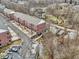Aerial view of brick townhomes with assigned parking next to wooded area and stream at 1072 3Rd Nw Ave, Carmel, IN 46032