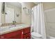Bathroom with cherry vanity, granite countertop, and a shower with a white shower curtain at 1072 3Rd Nw Ave, Carmel, IN 46032