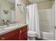 Bathroom with cherry vanity, granite countertop, and a shower with a white shower curtain at 1072 3Rd Nw Ave, Carmel, IN 46032