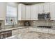 Charming kitchen with white cabinetry, granite countertops, stainless appliances and decorative window at 1072 3Rd Nw Ave, Carmel, IN 46032
