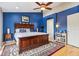 Comfortable main bedroom featuring dark blue accent wall, wooden bed frame, and soft rug on hardwood floors at 1072 3Rd Nw Ave, Carmel, IN 46032