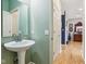 This powder room has a pedestal sink, a mirror, and access to the main hallway with hardwood floors at 1072 3Rd Nw Ave, Carmel, IN 46032