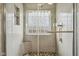 Spa-like shower with glass door, pebble floor, tiled walls, a built-in shower seat, and glass block window at 1072 3Rd Nw Ave, Carmel, IN 46032