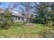Backyard with mature trees, green lawn, and windows overlooking the pleasant scenery at 12205 Whitebark Dr, Indianapolis, IN 46236