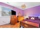 Cozy bedroom featuring a lilac color scheme, hardwood floors, and a unique stained glass light fixture at 12205 Whitebark Dr, Indianapolis, IN 46236