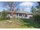 Charming single-story home with mature trees and lush green lawn on a sunny day at 12205 Whitebark Dr, Indianapolis, IN 46236