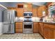 Well-equipped kitchen with stainless steel appliances, light wood cabinets, and patterned flooring at 12205 Whitebark Dr, Indianapolis, IN 46236