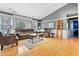 Bright living room featuring hardwood floors, wainscotting, large windows, and cozy seating at 12205 Whitebark Dr, Indianapolis, IN 46236