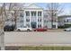 Three-story building showcasing classic architectural details, complemented by a row of parked cars at 12863 Tradd St # 1D, Carmel, IN 46032