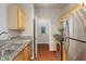 Open kitchen with stainless appliances and view into laundry room at 12863 Tradd St # 1D, Carmel, IN 46032