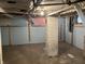 Basement space with a brick support column and exposed utilities at 2025 Main St, Elwood, IN 46036