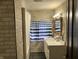 Updated bath with vanity, mirror, and blue striped shower curtain at 2025 Main St, Elwood, IN 46036