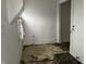 A room with damaged tile and a view to another room at 2025 Main St, Elwood, IN 46036