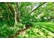 Serene backyard featuring a small creek, lush greenery, and mature trees at 2850 Tansel Rd, Indianapolis, IN 46234