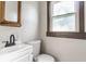 Cozy bathroom with white vanity, toilet, classic mirror and a window at 3543 N Kenwood Ave, Indianapolis, IN 46208