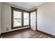 The light and airy bedroom features two windows and wood look flooring at 3543 N Kenwood Ave, Indianapolis, IN 46208