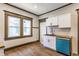 Bright kitchen featuring white cabinets, a blue dishwasher, and wood-look flooring at 3543 N Kenwood Ave, Indianapolis, IN 46208