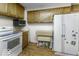 Functional kitchen with wood cabinets, a white refrigerator, and essential appliances for meal preparation at 3807 S Olney St, Indianapolis, IN 46237