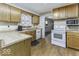Well-lit kitchen featuring wood cabinets, laminate countertops, and white appliances, ideal for cooking at 3807 S Olney St, Indianapolis, IN 46237