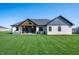 Well-maintained backyard featuring a covered patio, a spacious lawn, and elegant architectural details at 413 Cardinal Dr, Jamestown, IN 46147