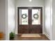 Welcoming foyer featuring glass-paneled double doors, hardwood floors, and a jute rug at 413 Cardinal Dr, Jamestown, IN 46147