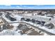 Aerial view of homes during winter, lined with snow, showcasing a peaceful neighborhood under a clear blue sky and scattered clouds at 5461 Oak Knoll Dr, Whitestown, IN 46075