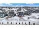 Aerial view of a new home community during winter with snow-covered yards, a view of a backyard, and clear, blue skies at 5461 Oak Knoll Dr, Whitestown, IN 46075