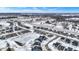 New home community in winter with snow-covered lawns, frozen pond, and contemporary single-Gathering homes under a blue sky at 5461 Oak Knoll Dr, Whitestown, IN 46075