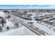 Areal view of a new neighborhood with snow-covered yards, modern homes and a frozen pond at 5461 Oak Knoll Dr, Whitestown, IN 46075